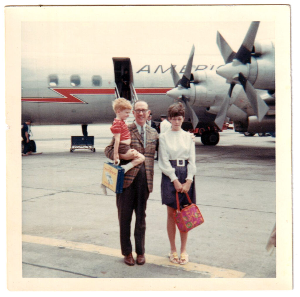 Vintage travel photo of family at airport with American Airlines plan. 