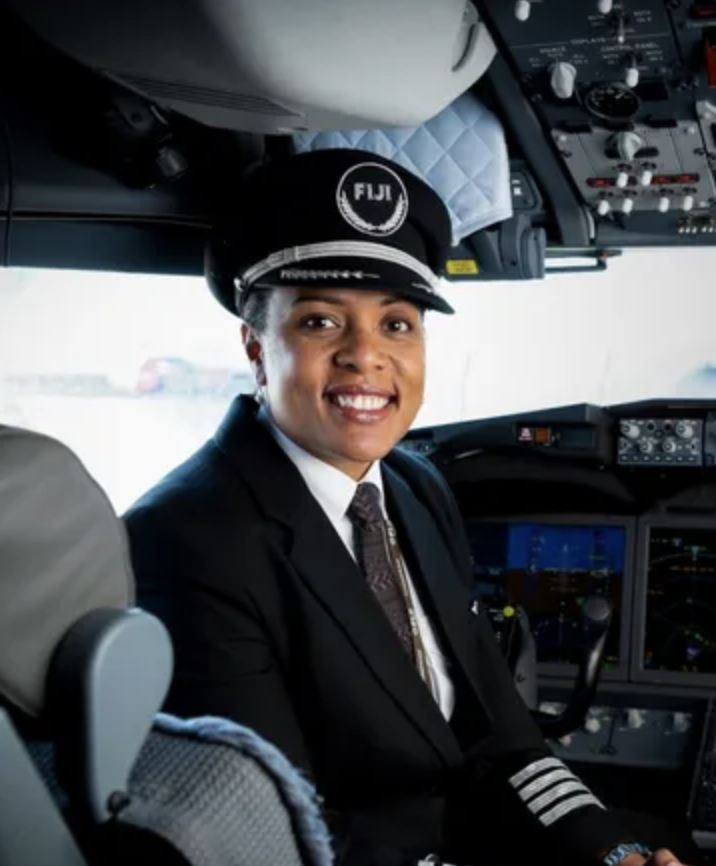 woman airline pilot sitting in cockpit of commercial jet
